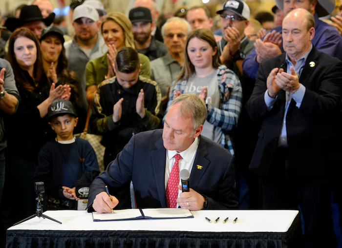 Ryan Zinke holding sectorial order with group of supporters